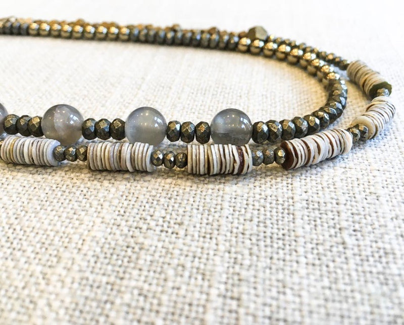 side view  of gemstone bead necklace comprising grey moonstone, grey shell and metallics