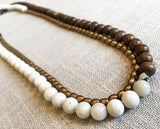 top view of gemstone bead necklace comprising off-white siberian moonstone, exotic wood and bronze