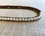 side view of gemstone bead necklace comprising white moonstone, exotic wood and metallics