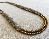 top view of gemstone bead necklace comprising black tahitian shell, grey moonstone and gold hematite