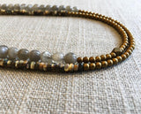 side view of gemstone bead necklace comprising black tahitian shell, grey moonstone and matte gold