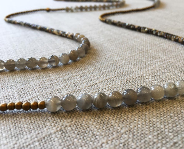 closeup of gemstone bead necklace comprising black tahitian shell, grey moonstone and gold hematite