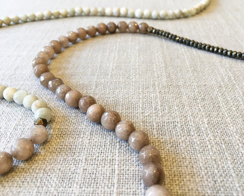 closeup of gemstone bead necklace comprising taupe quartz, white siberian moonstone and dark grey pyrite