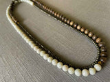 top view of gemstone bead necklace comprising white moonstone, dark grey pyrite and exotic wood