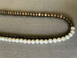 side view of gemstone bead necklace comprising white moonstone, dark grey pyrite and exotic wood