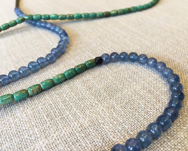 closeup of gemstone bead necklace comprising blue blue apatite, turquoise and dark grey pyrite