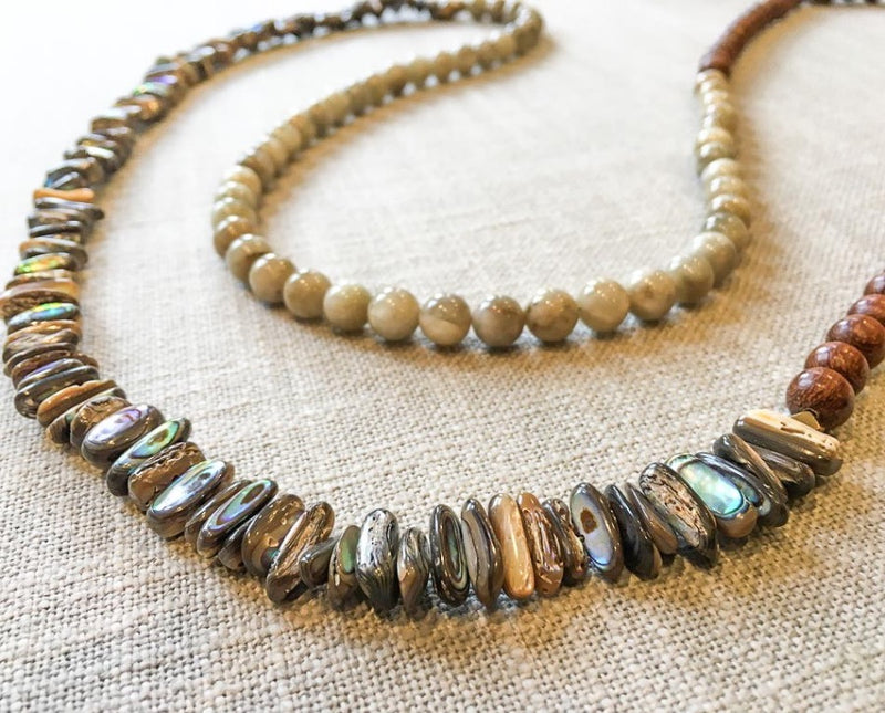 closeup of gemstone bead necklace comprising off-white siberian moonstone, exotic wood and black tahitian shell nuggets