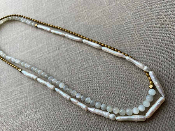 top view of gemstone bead necklace comprising white moonstone, white stick pearl, gold hematite