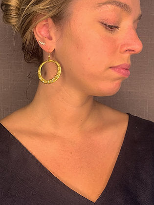 model wearing organic-shaped gold earrings