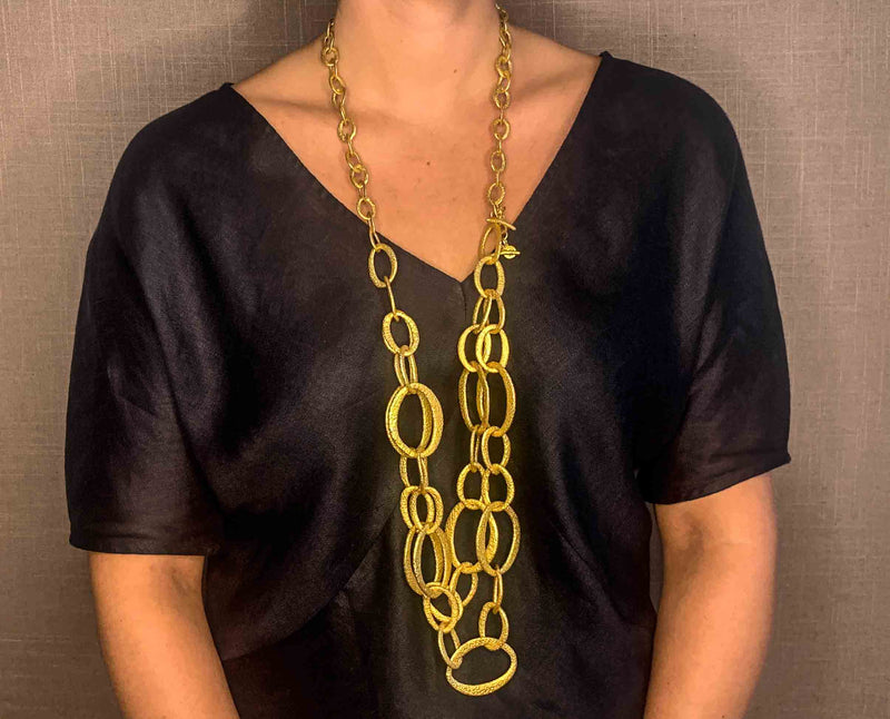 model wearing organic-shaped gold necklace