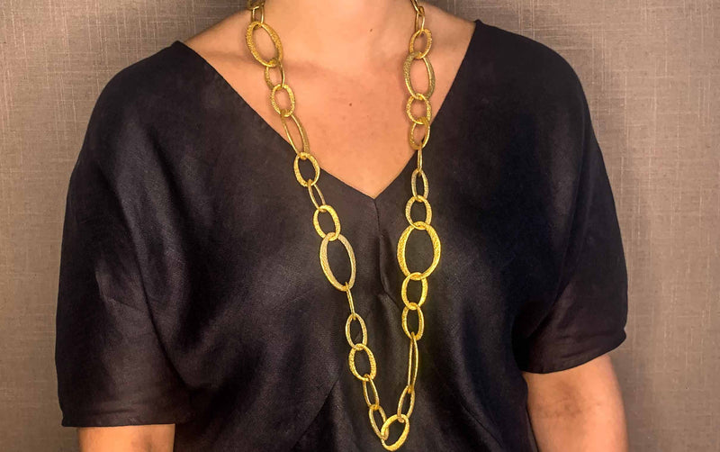 model wearing organic-shaped gold necklace