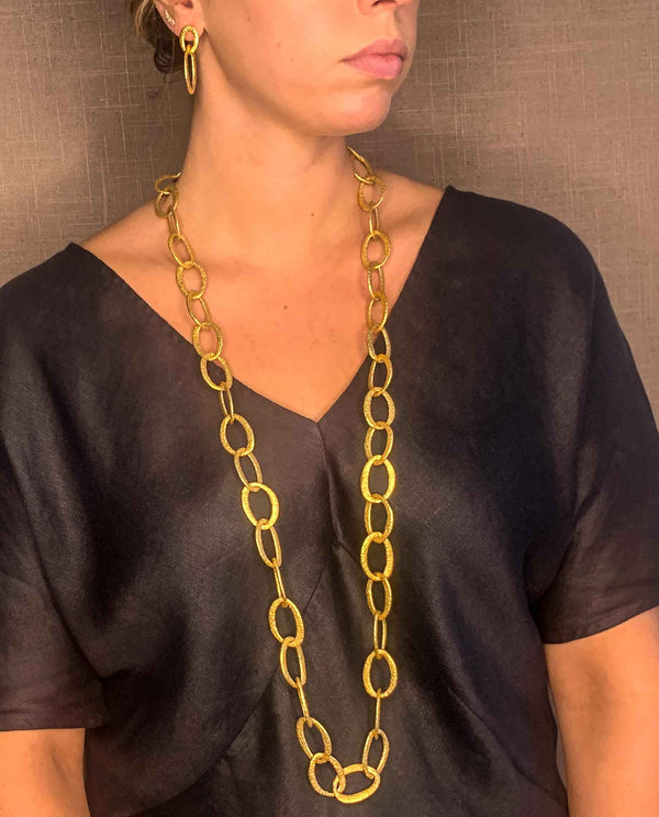 model wearing organic-shaped gold necklace