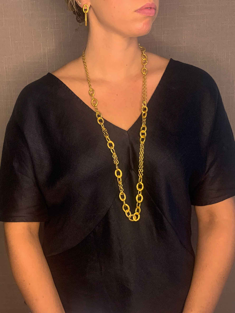 model wearing organic-shaped gold necklace