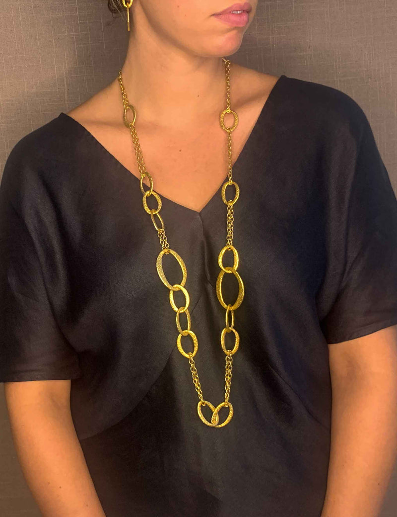 model wearing organic-shaped gold necklace