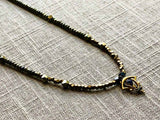 closeup of antique art nouveau pendant hung on metallic bead choker