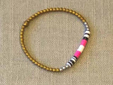 heishi bead bracelet comprising vinyl discs in a pink and white racing stripe and metallic beads