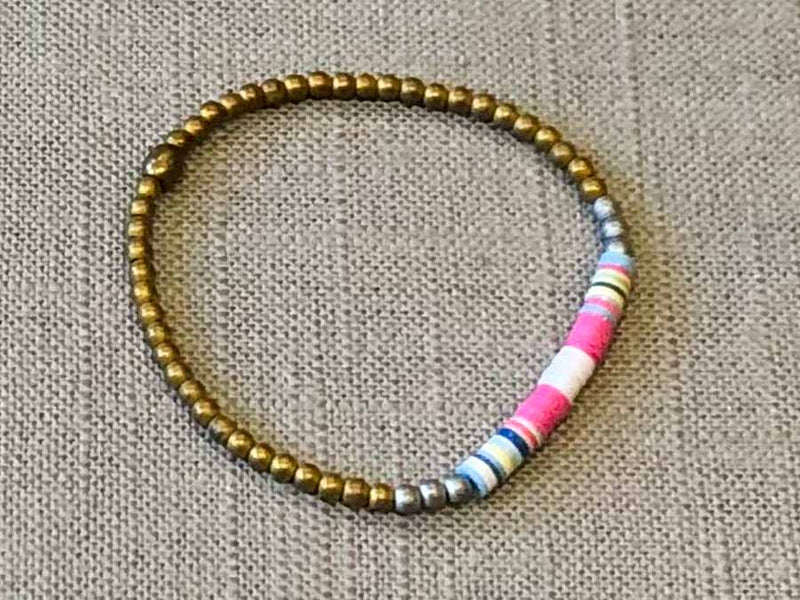 heishi bead bracelet comprising vinyl discs in a pink and white racing stripe and metallic beads