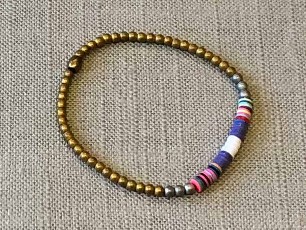 heishi bead bracelet comprising vinyl discs in a purple and white racing stripe and metallic beads