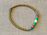 heishi bead bracelet comprising vinyl discs in a green and white racing stripe and metallic beads