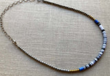 heishi necklace comprising vinyl discs in a black and white mix and metallic beads