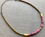 heishi necklace comprising vinyl discs in a pink multi mix and metallic beads