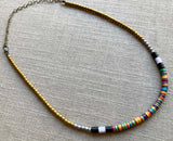 heishi necklace comprising vinyl discs in an orange multi mix and metallic beads