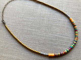 heishi necklace comprising vinyl discs in an orange multi mix and metallic beads