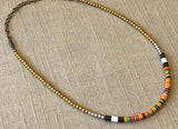 heishi necklace comprising vinyl discs in an orange multi mix and metallic beads