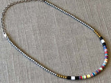 heishi necklace comprising vinyl discs in a red multi mix and metallic beads