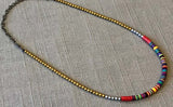 heishi necklace comprising vinyl discs in a red multi mix and metallic beads