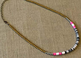 heishi necklace comprising vinyl discs in a black and white mix and metallic beads