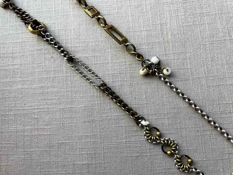 closeup of fragment chain necklace with vintage and reclaimed chain elements and various trade beads