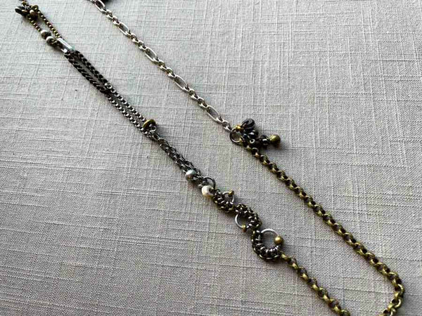 top view of fragment chain necklace with vintage and reclaimed chain elements and various trade beads