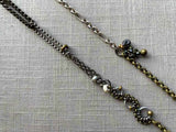 closeup of fragment chain necklace with vintage and reclaimed chain elements and various trade beads