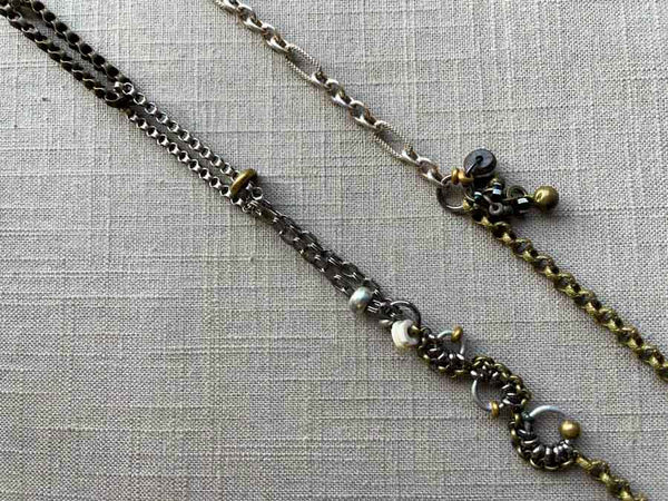 closeup of fragment chain necklace with vintage and reclaimed chain elements and various trade beads