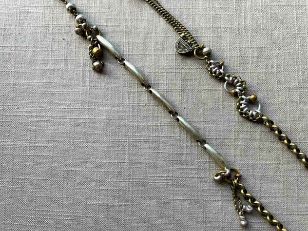 closeup of fragment chain necklace with vintage and reclaimed chain elements and various trade beads