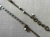 closeup of fragment chain necklace with vintage and reclaimed chain elements and various trade beads