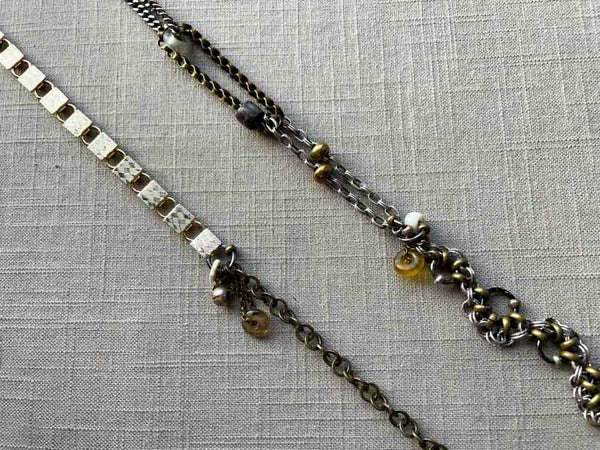 closeup of fragment chain necklace with vintage and reclaimed chain elements and various trade beads