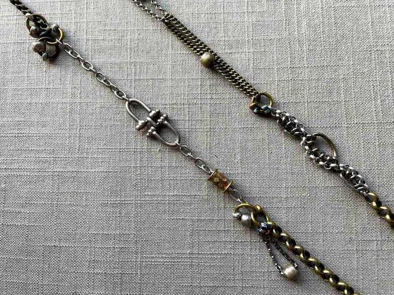 closeup of fragment chain necklace with vintage and reclaimed chain elements and various trade beads