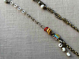 closeup of fragment chain necklace with vintage and reclaimed chain elements and various trade beads