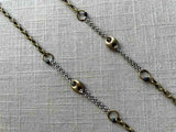 closeup of mariner link necklace with mixed metal chain pattern