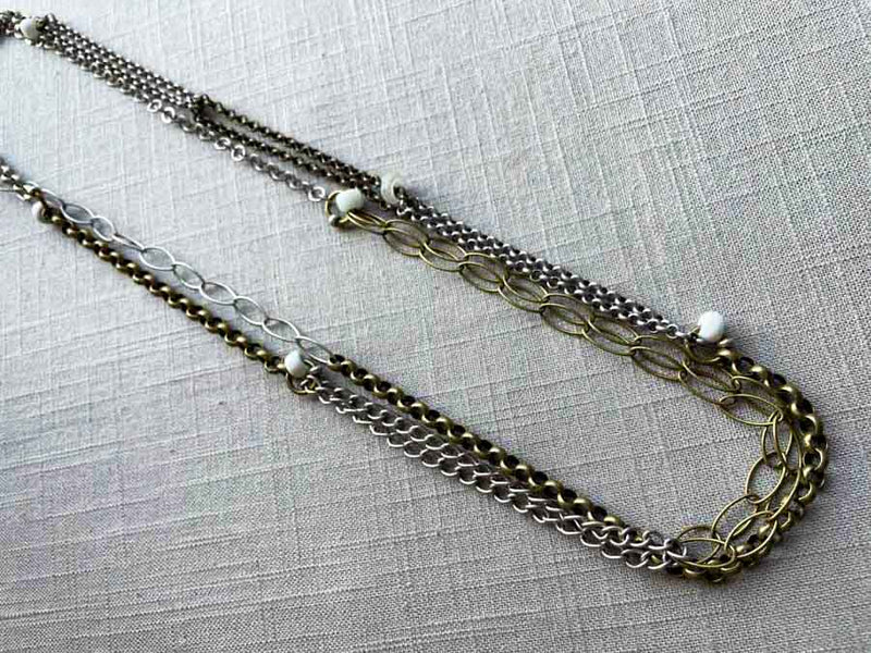 top view of 64"L mixed metal chain necklace with white padre beads