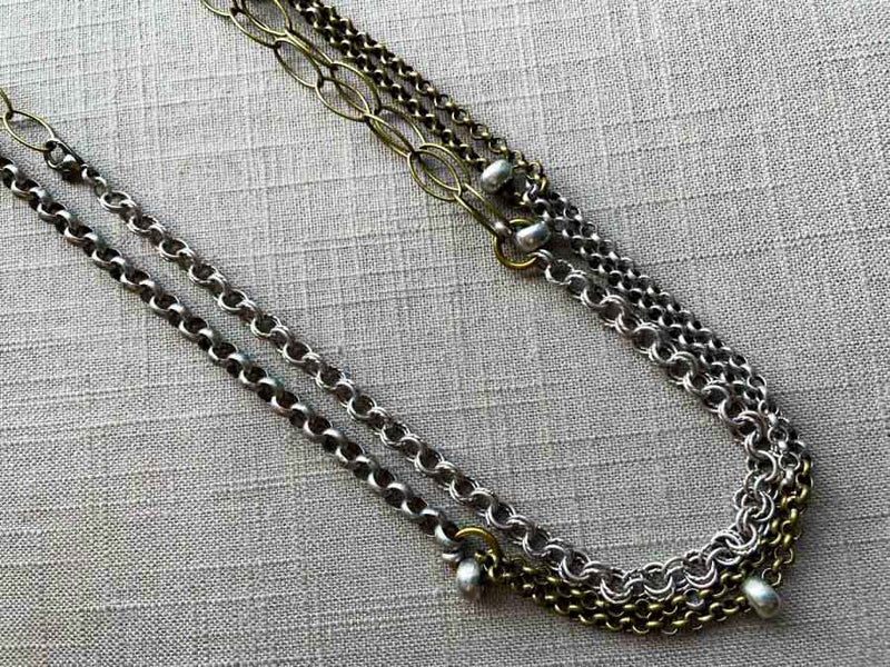 closeup of 64"L mixed metal chain necklace with silver beads