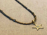 closeup of pave star pendant hung on metallic bead choker