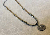 top view of pave disc pendant hung on metallic bead choker