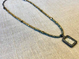 top view of pave diamond shaker pendant hung on metallic bead choker