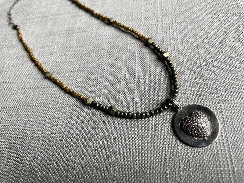 top view of pave puff heart pendant hung on a metallic bead choker