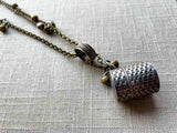 closeup of antique sterling silver thimble holder on chain mix