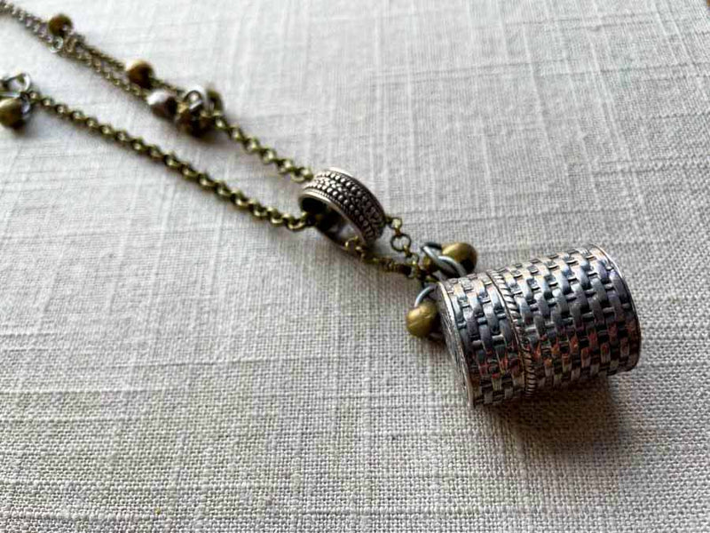 closeup of antique sterling silver thimble holder on chain mix