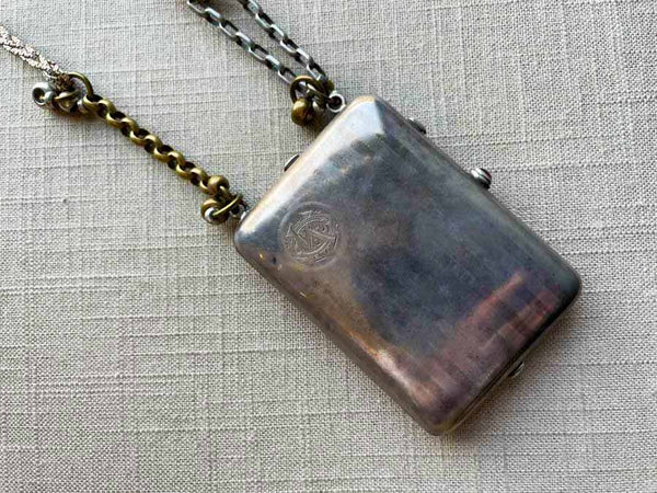 closeup of antique sterling silver compact/change holder/notepad on chain mix